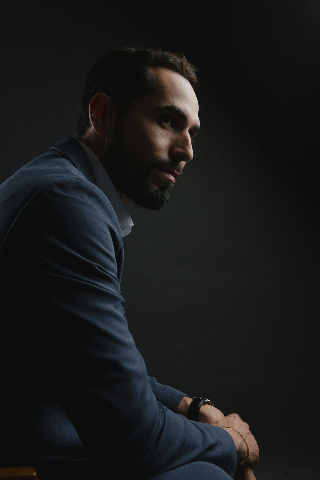 Cinematic moody portrait of a well-dressed man in a dark suit