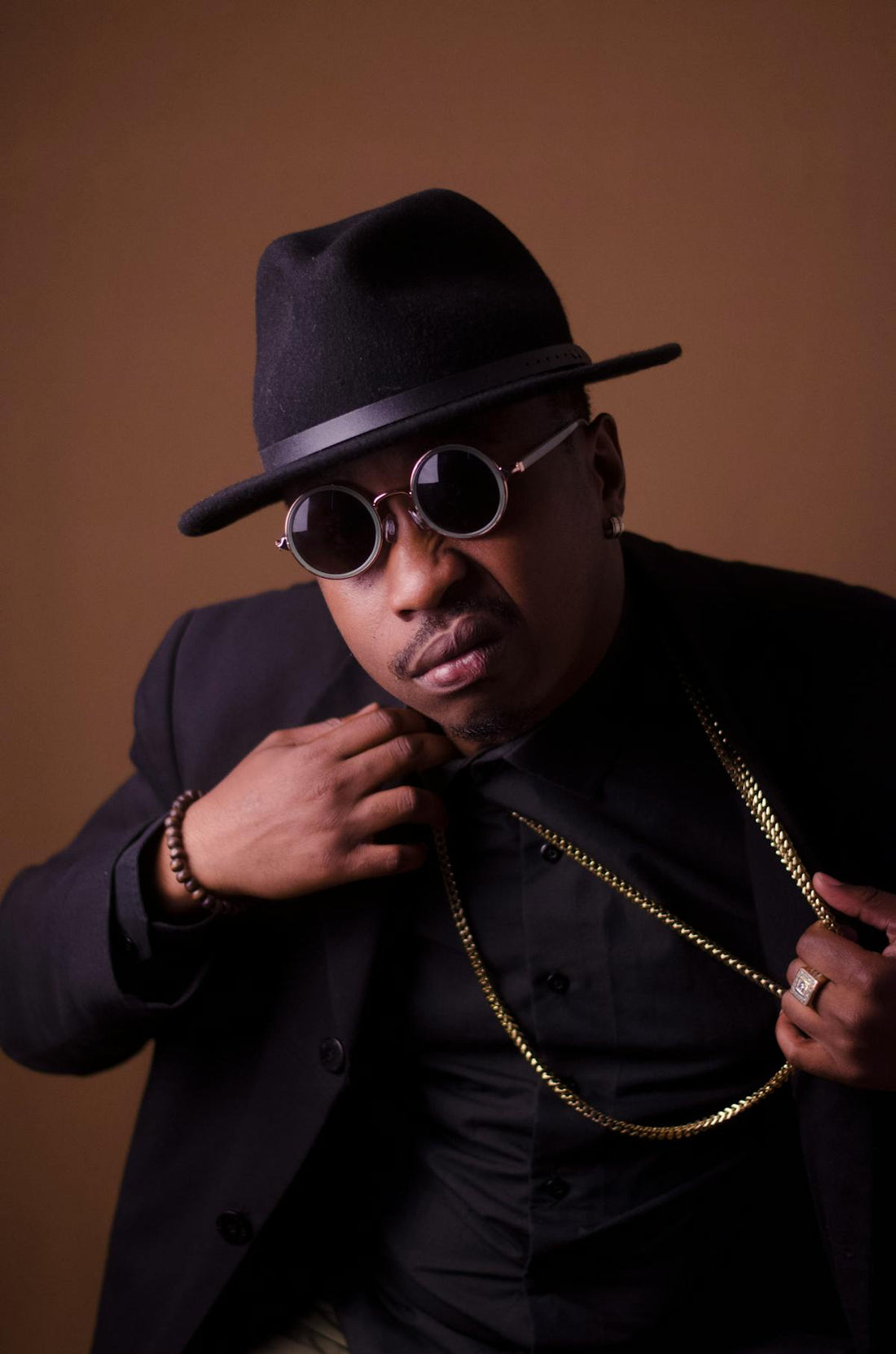 Man in black blazer wearing a gold chain